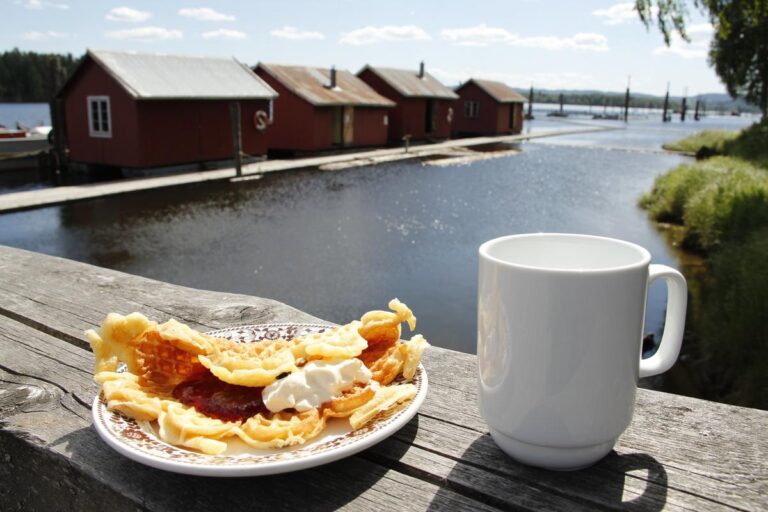 En kopp kaffe og en vaffel med rømme ved bryggekanten