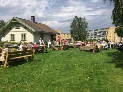 Lurkahuset med mennesker og benker foran